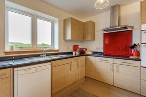 A modern kitchen with a dishwasher, a sink, and a window. - 4 Bed in Lairg (oc-ca417) (Lochinver)