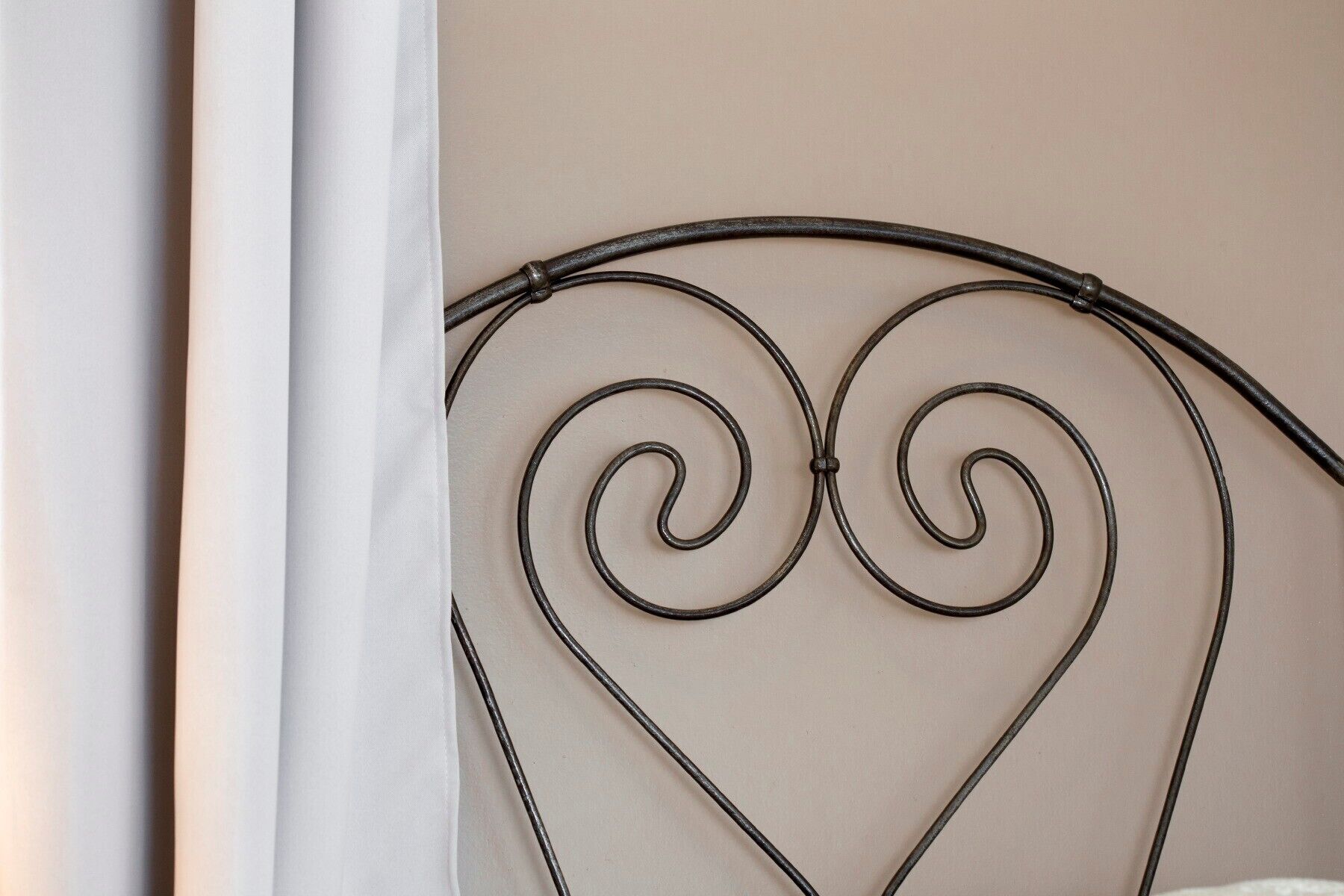 Una testiera in metallo con decorazioni a forma di cuore.