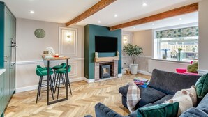 A living room with a fireplace, a TV, a sofa, and a dining area with chairs. - 2 Bed in Thornton (oc-h36043) (Thornton)