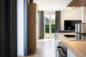 A modern kitchen with a wooden countertop, stainless steel appliances, and a large window. - MeerNah Grömitz Apartment 6. Family-friendly. Infrared cabin. Patio (Grömitz)