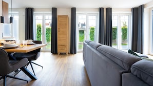 Ein modernes Wohnzimmer mit Sofa, Esstisch und Kleiderschrank.
