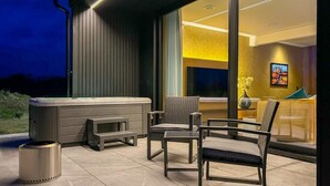 An outdoor patio with a hot tub, seating, and a trash can. - 1 Bed in Oban (oc-t41733) (Achacha)