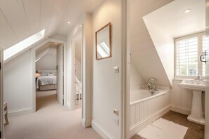 Un dormitorio con cama, mesita de noche y velador.