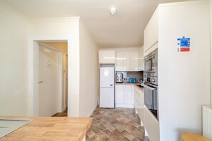 A compact kitchen with white cabinets, a refrigerator, a microwave, and a toaster. - 2 Bed in Dalrymple (oc-b40270) (Dalrymple)