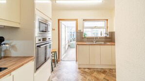 A kitchen with a microwave, oven, and sink, wooden countertops, and a view to the outside. - 2 Bed in Dalrymple (oc-b40270) (Dalrymple)