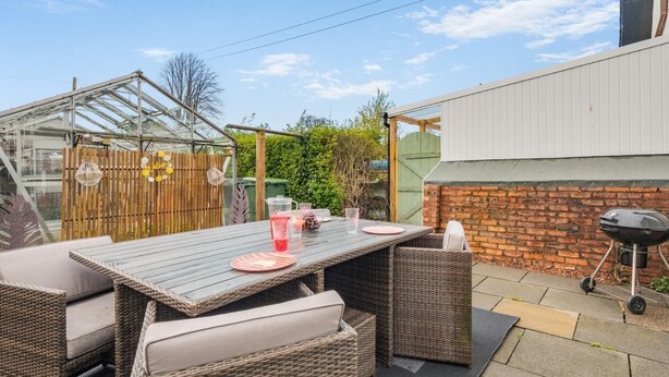 A patio with a table and chairs, a barbecue grill, and a greenhouse. - 2 Bed in Dalrymple (oc-b40270) (Dalrymple)