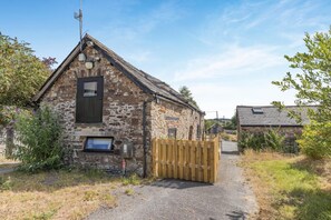 A stone building with a wooden gate, a small window, and a sign on the door. - 2 Bed in Dulverton (oc-h34793) (Brushford)