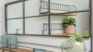 A wall-mounted shelf unit with a mirror, two vases, and a potted plant. - 2 Bed in Warkworth (oc-coq103) (Warkworth)