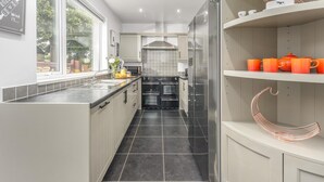 A modern kitchen with a central island, stainless steel appliances, and a window providing natural light. - 2 Bed in Warkworth (oc-coq103) (Warkworth)