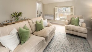 A living room with a beige sofa, a matching armchair, and a patterned rug. - 2 Bed in Warkworth (oc-coq123) (Warkworth)