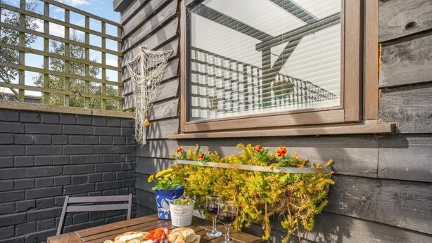 A wooden table with a cheese board, wine glasses, and a potted plant. - 1 Bed in Heacham (oc-c40224) (Heacham)