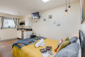 A compact room with a bed, a small kitchenette, a TV, and a window with curtains. - 1 Bed in Heacham (oc-c40228) (Heacham)