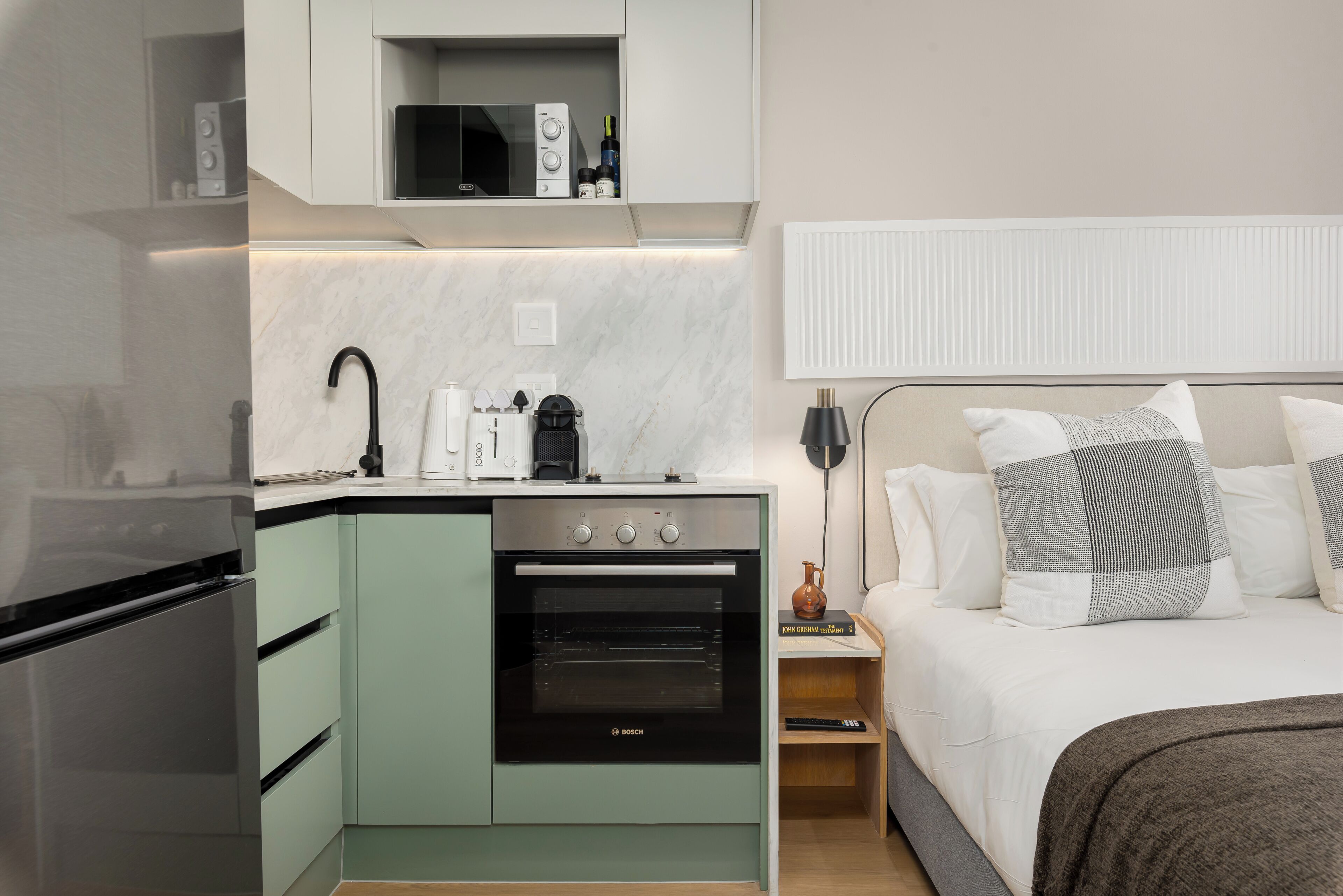 A compact kitchen with a Bosch oven, a coffee maker, and a microwave.