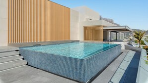 Una piscina infinita a la terrassa amb una vista despejada del perfil urbà.