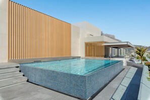 Ein Infinity-Pool auf dem Dach mit freiem Blick auf die Stadtlandschaft.
