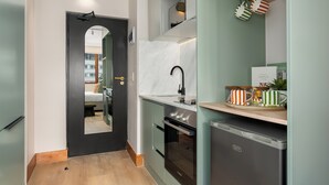 Una cocina moderna con puerta negra, salpicadero de mármol blanco y electrodomésticos de acero inoxidable.