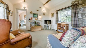 A cozy living room with a fireplace, a television, and a comfortable seating area. - 1 Bed in Edlingham (oc-g41396) (Edlingham)