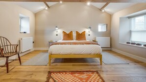 Ein Schlafzimmer mit einem Holzbett, zwei Nachttischlampen, einem Fenster und einer Heizung.