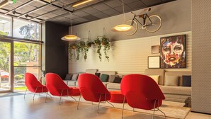 A modern interior with a seating area, a sofa, hanging plants, and a bicycle.