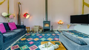 A living room with a sofa, a television, a fireplace, and a patterned rug. - 4 Bed in Beguildy (oc-t41741) (Beguildy)