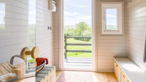 A room with a wooden interior, a bench, a window, and a view of greenery outside. - 4 Bed in Beguildy (oc-t41741) (Beguildy)