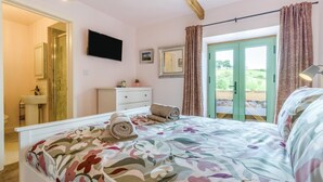 A bedroom with a bed, a dresser, a television, and a door leading to an outdoor area. - 4 Bed in Beguildy (oc-t41741) (Beguildy)