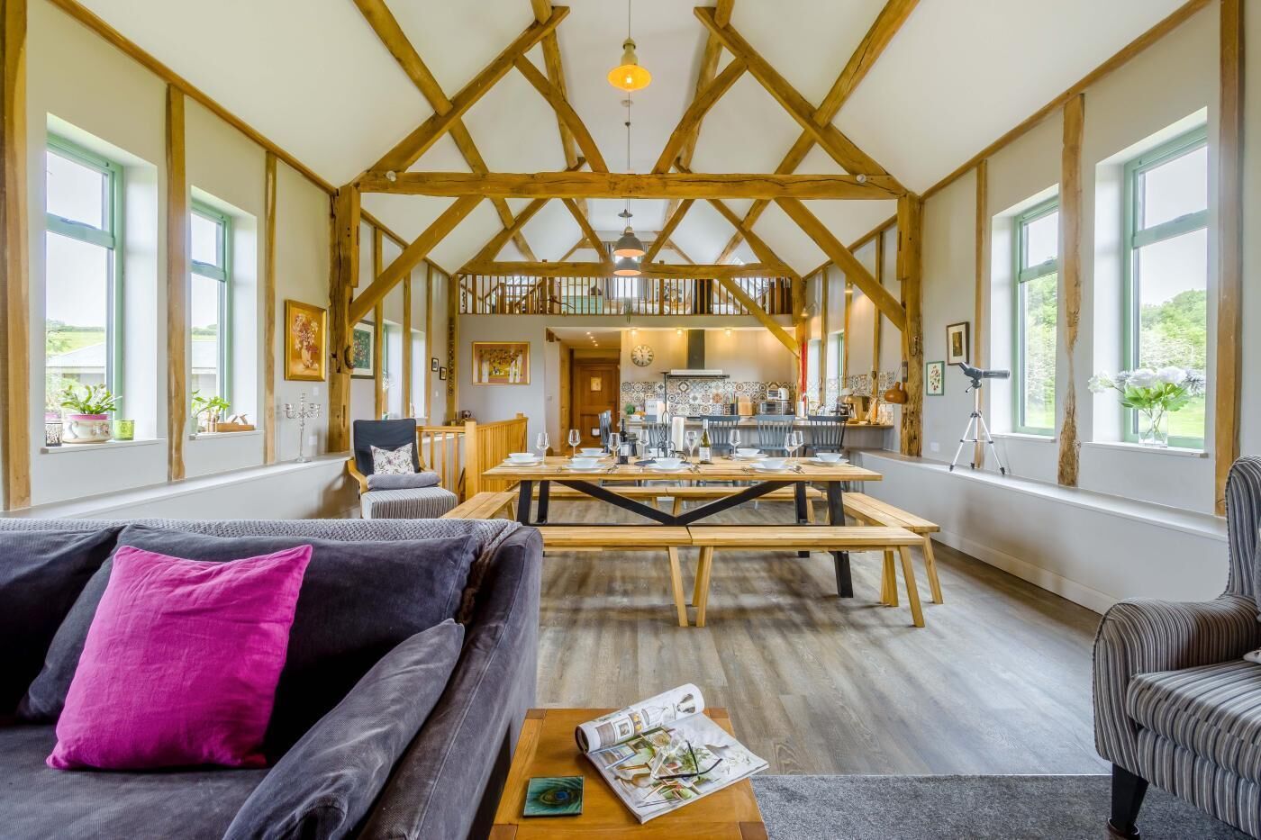Een ruime woonkamer met een eettafel, banken en een keuken op de achtergrond.