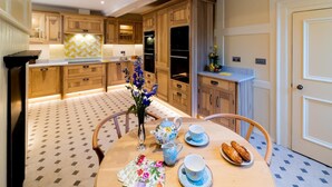 A kitchen with wooden cabinets, a tiled floor, a dining table with chairs, and a vase with flowers. - 2 Bed in Oxford (oc-s41047) (Oxford)