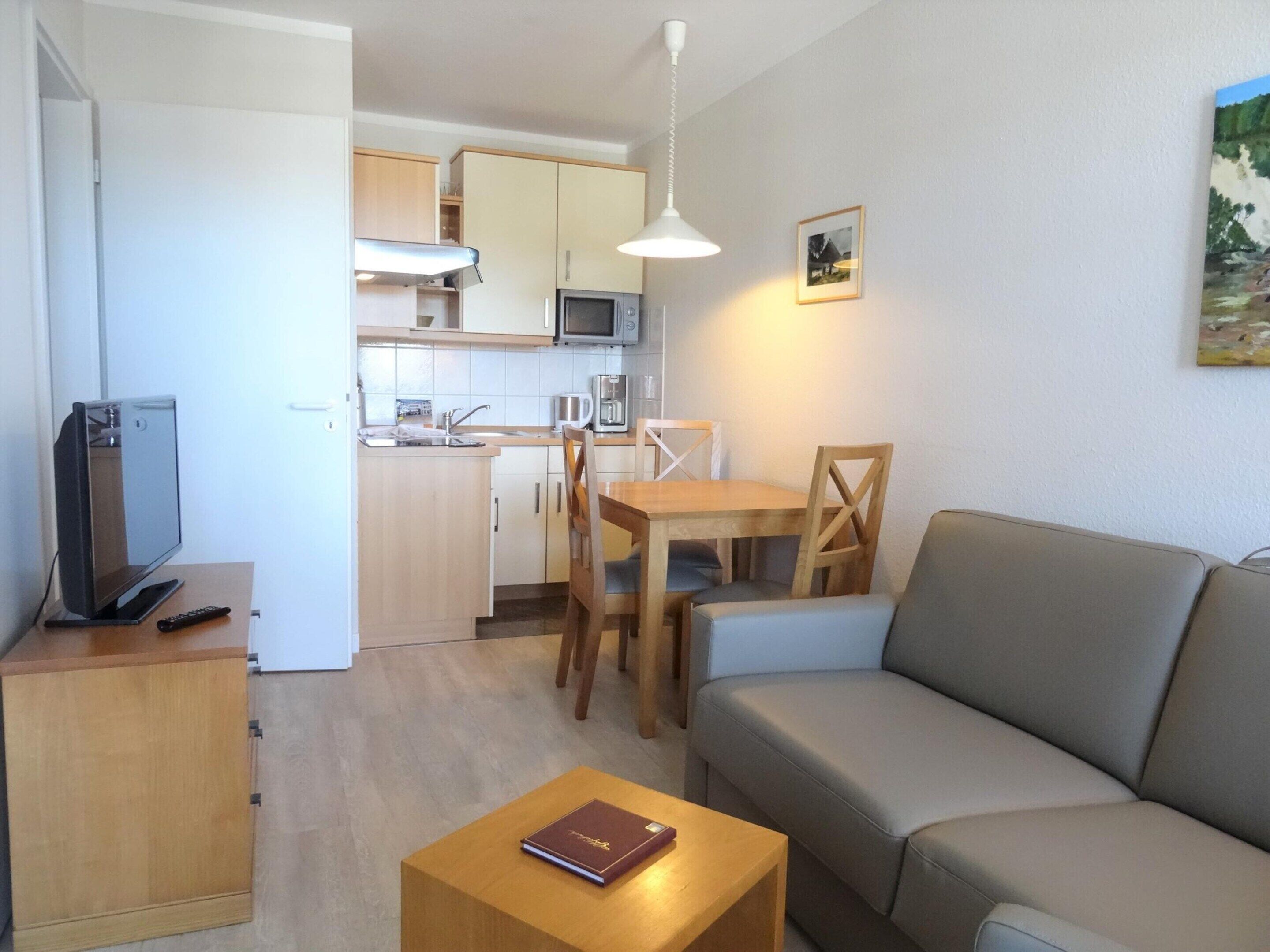 A compact living space with a kitchenette, a dining area, and a seating area.