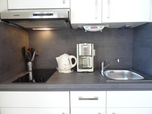 A modern kitchen with a built-in stove, a coffee maker, and a sink. - Fantastisches Studio im Seepark Sellin mit Balkon (Sellin)