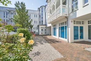 A hotel with a gravel pathway, a rose garden, and a building with a balcony. - Fantastisches Studio im Seepark Sellin mit Balkon (Sellin)