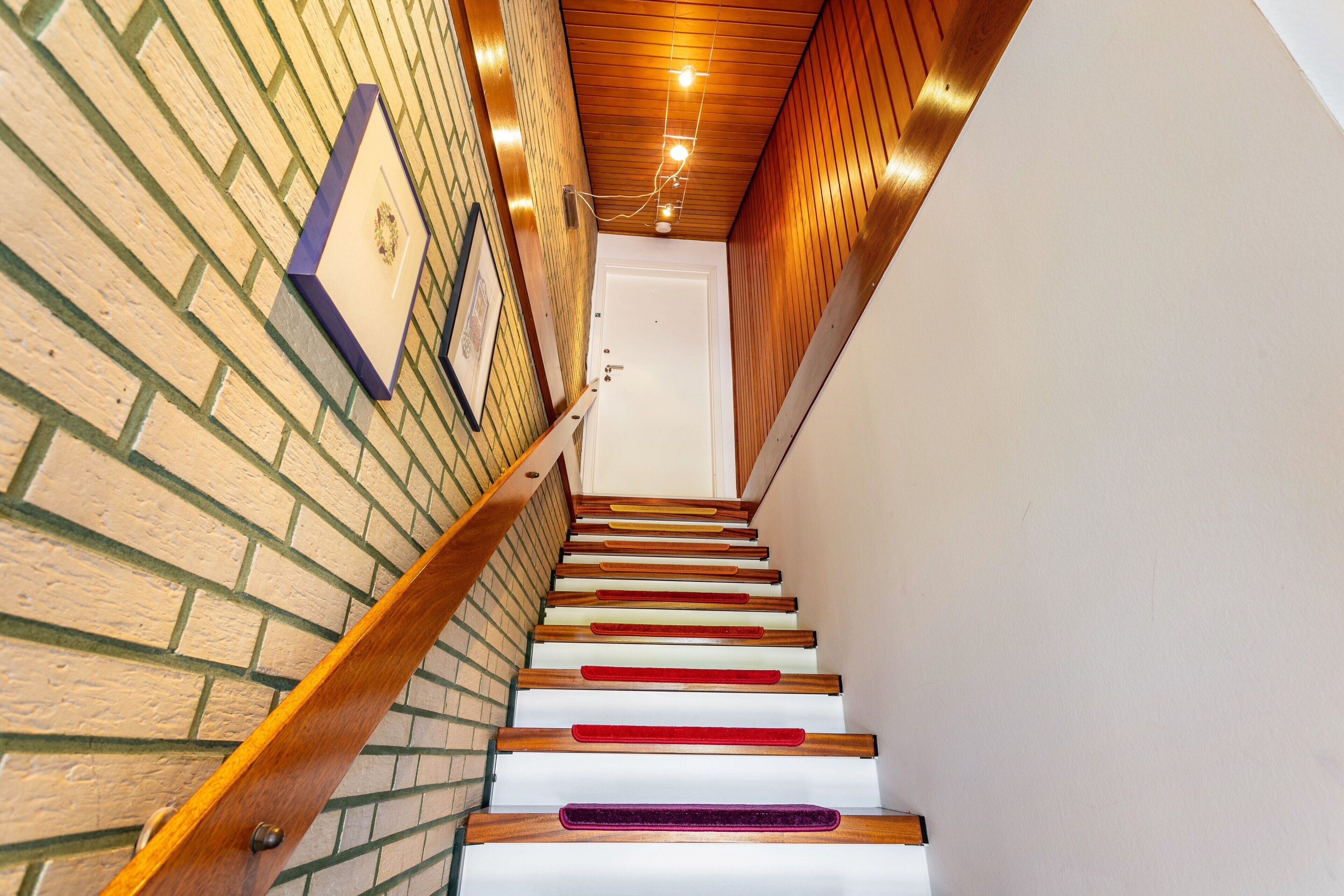 Eine Treppe mit Holzdielen und einer Ziegelwand.