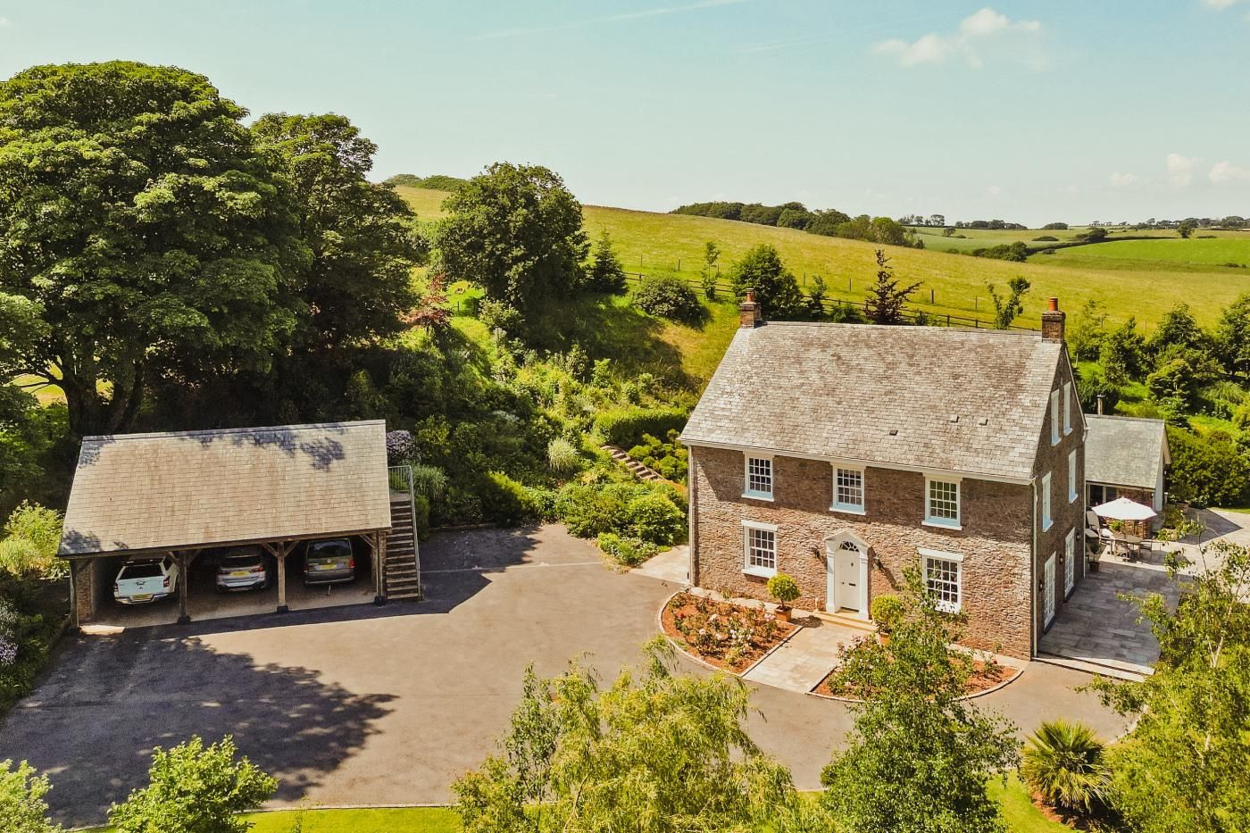 A stone house with a garage and a paved driveway.