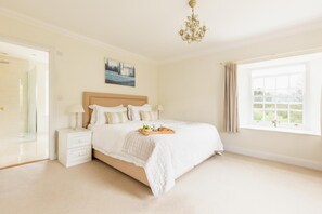 A bedroom with a bed, bedside tables, a chandelier, a painting, and a window with curtains. - 5 Bed in Slapton (oc-s41370) (Slapton)