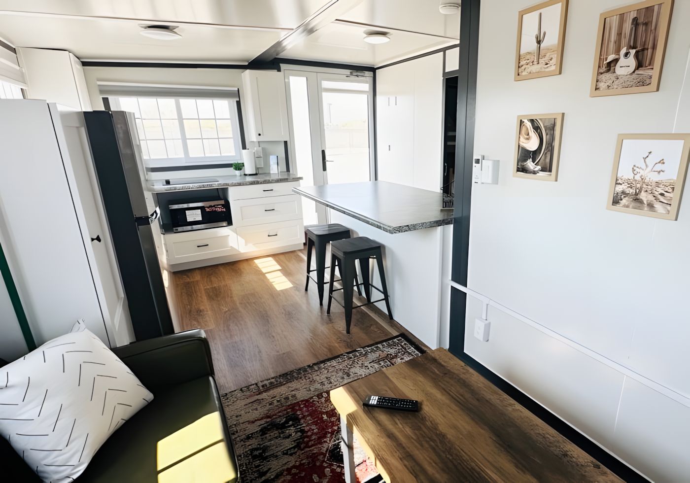 A compact living space with a kitchenette, a dining area, and a seating area with a sofa and a coffee table.