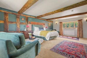 Quarto com cama, sofá, cômoda e janela com cortinas.