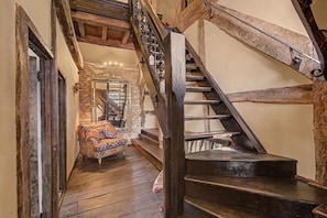 A staircase with wooden railings and a stone wall.