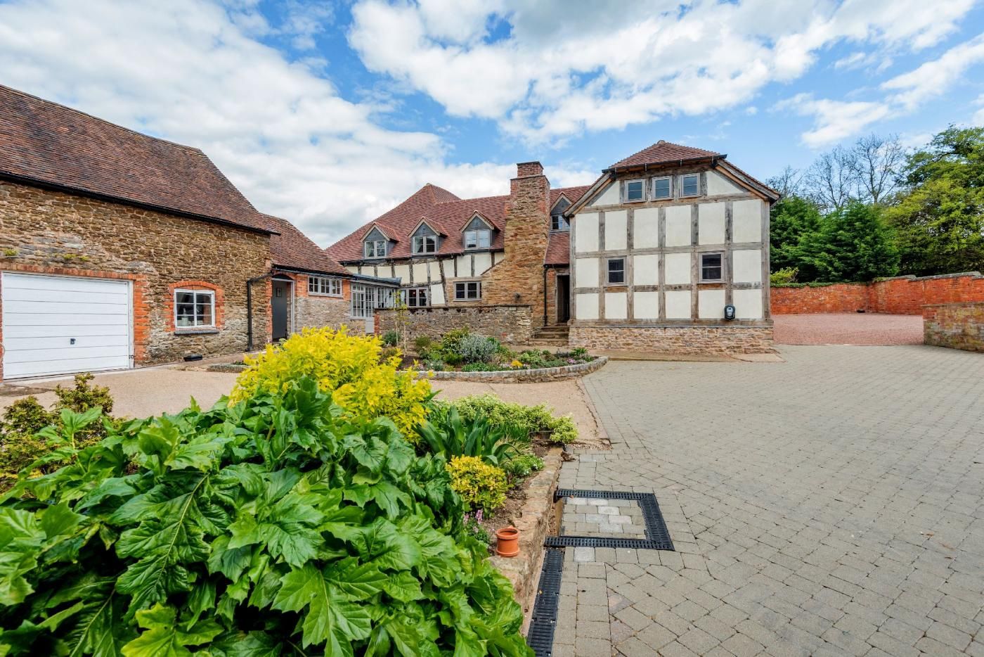 A residential property with a stone facade, a large garage, and a paved driveway.