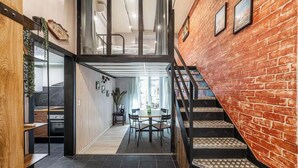 Un intérieur moderne comprenant un escalier, un coin repas et une cuisine.