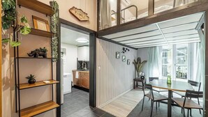 Un intérieur moderne comprenant un coin repas, une cuisine et une vue sur l’extérieur.
