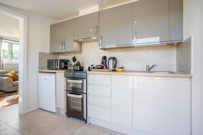A modern kitchen with stainless steel appliances, a built-in oven, and a sink. - 1 Bed in Brockenhurst (oc-f40681) (Brockenhurst)