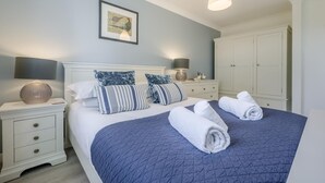 A bedroom with a bed, two bedside tables, a nightstand, a wardrobe, and a framed picture on the wall. - 2 Bed in St. Merryn (oc-b14684) (Saint Merryn)