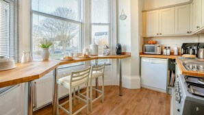 A kitchen with a wooden countertop, white appliances, and a view through large windows. - 2 Bed in Scarborough (oc-g34248) (Scarborough)