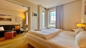 Et hotelværelse med en stor seng, en sofa, en stol og et skrivebord.