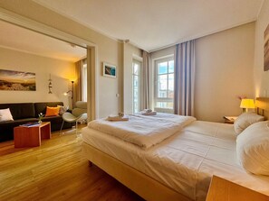 A hotel room with a large bed, a sofa, a chair, and a desk. - Gemutliche Ferienwohnung Nahe Ostseestrand in Sellin (Sellin)