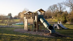 A playground with a slide and climbing structures.