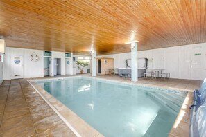 An indoor swimming pool with a wooden ceiling, tiled floor, and a lifebuoy on the wall. - 2 Bed in Bideford (oc-73954) (Hartland)