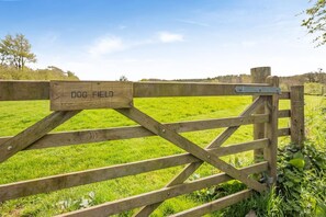 A wooden gate with a sign reading 'DOG FIELD' in a grassy field. - 2 Bed in Bideford (oc-73954) (Hartland)
