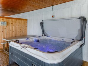 A hot tub with a control panel, a table, and a wooden wall. - 2 Bed in Bideford (oc-73954) (Hartland)
