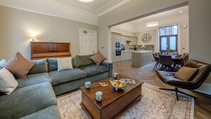 Un salon comprenant un canapé, une table basse et un coin repas avec des chaises et une table.
